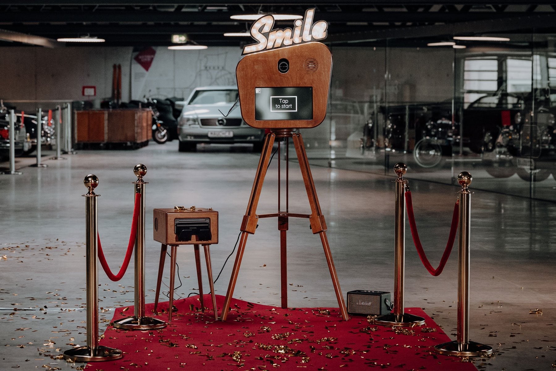 Fotobox «Smile» mieten: Holzbox mit leuchtendem Smile-Schild aus Glühbirnen auf Holzstativ, Studioaufnahme